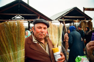Ukrainian selling brooms and candles at Kosiv Market - Ukraine